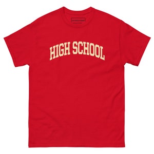 以下が含まれることがあります： 黄色いアーチの中に「HIGH SCHOOL」の文字が入った赤い半袖Tシャツです。