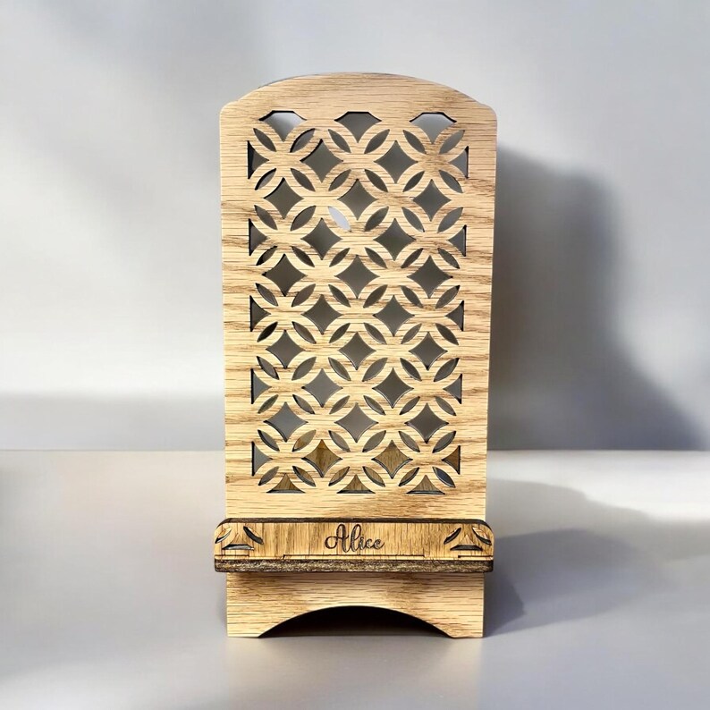 May include: A wooden phone stand with a geometric cutout design and the name "Alice" engraved on the base.