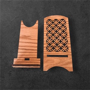May include: A wooden stand with a decorative cutout design. The stand is made of light brown wood and has a rectangular base. The cutout design is a repeating pattern of circles and ovals.