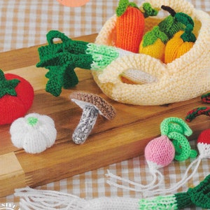 May include: A set of knitted vegetables, including a tomato, garlic, mushroom, radish, and a bag of carrots, onions, and potatoes. The vegetables are all hand-knitted and have realistic details.