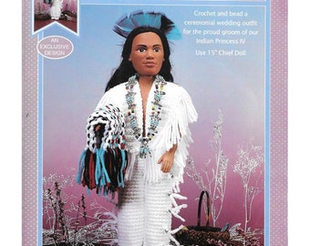 May include: Crocheted doll outfit for a 15 inch doll. The doll is wearing a white outfit with beaded jewelry and a blue and white headdress. The doll is holding a blue, white, and black crocheted blanket. The text "CHIEF IV" is at the top of the image. The text "AN EXCLUSIVE DESIGN" is in a circle at the bottom left of the image.