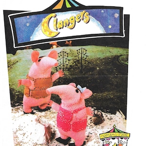 Puede incluir: Dos personajes de juguete de punto rosa del programa de televisión infantil "Clangers". Los personajes están de pie sobre una superficie blanca con un fondo verde. Los personajes llevan atuendos rosas y marrones. Los personajes están mirando un cartel que dice "Clangers".