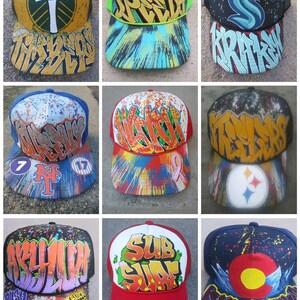 May include: Nine different baseball caps with various designs and colors. The caps feature a variety of logos, including a hammer and axe, a green S, a Steelers logo, and a Sub Surf logo. The caps are all made of a mesh material and have a curved brim.