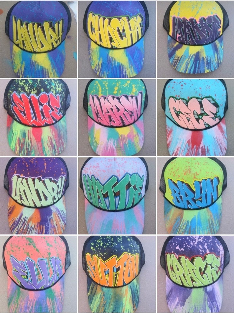 May include: Twelve colorful trucker hats with different names written in graffiti style on the front. The hats are all black mesh with a variety of colors and patterns on the front.