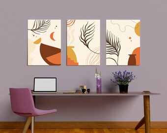 May include: Three abstract art prints with a cream background and brown, orange, and yellow geometric shapes and leaf designs. The prints are hanging on a light purple wall above a wooden desk with a laptop, a vase of flowers, and a pair of sunglasses.