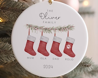 May include: White ceramic Christmas ornament with a red and white stocking design. The ornament reads "The Oliver Family" and "2024".