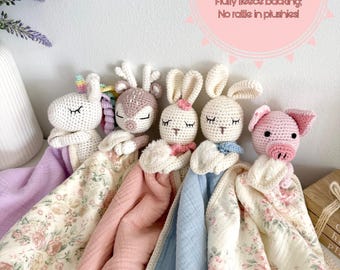 Peut inclure: Cinq doudous en crochet avec des dessus en coton mousseline biologique et des dos en polaire duveteuse. Les peluches incluent une licorne, un cerf, deux lapins et un cochon. Le texte indique : Blankie size: 14x14, Washcloth size, Organic muslin cotton top, Fluffy fleece backing, No rattle in plushies.