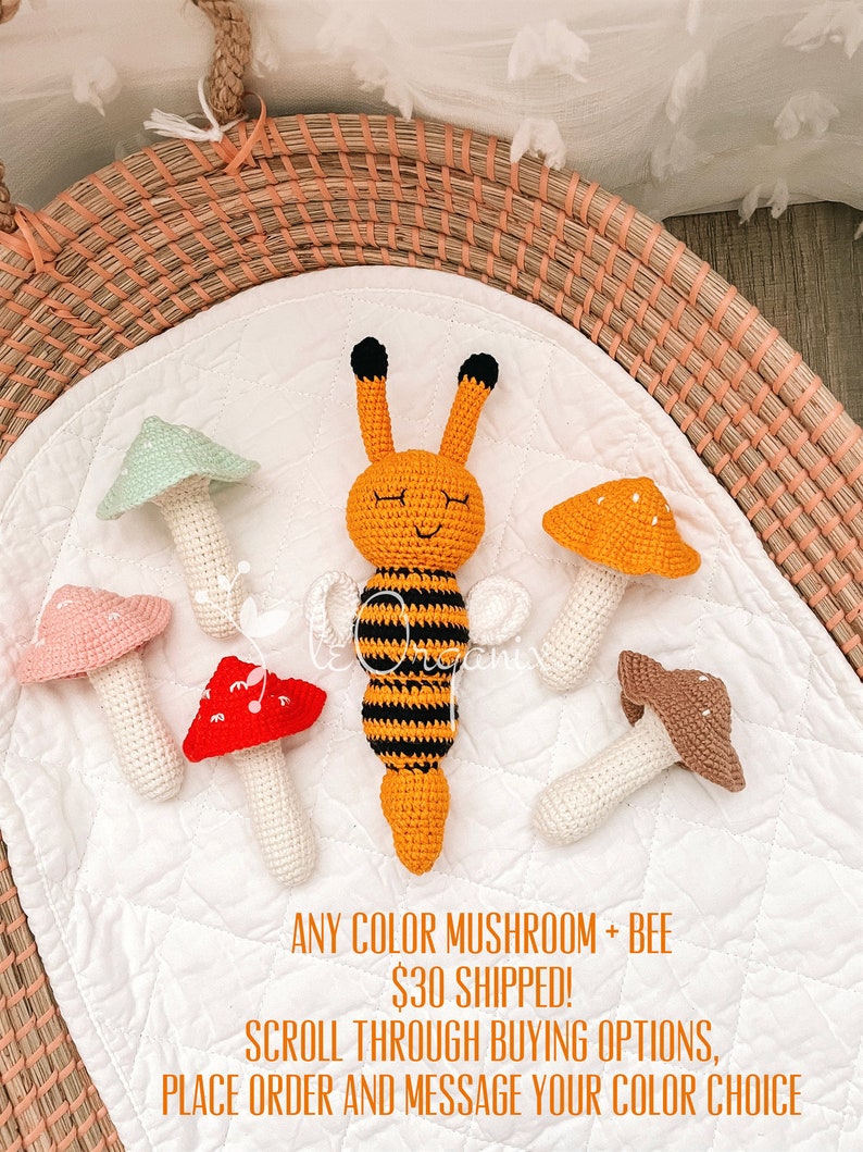 May include: A collection of five crocheted items including a central orange and black striped bee with antennae and four mushrooms in light green, pink, red, and orange with white spots. The text reads ANY COLOR MUSHROOM + BEE $30 SHIPPED!