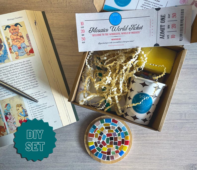 May include: A DIY mosaic kit with a colourful mosaic tile coaster, a small container of mosaic tiles, a sponge, and a ticket that says "Mosaics World Ticket".