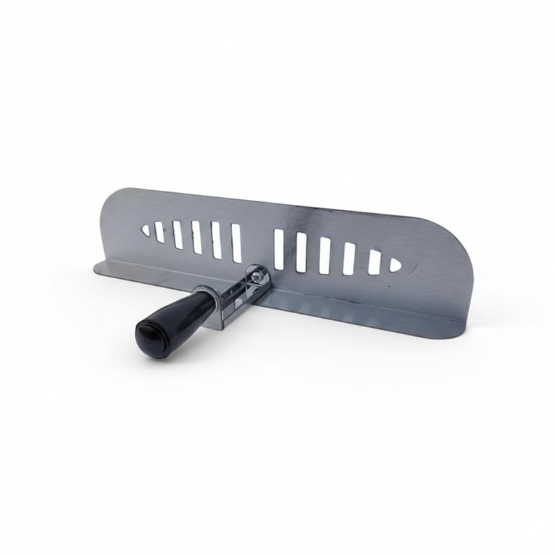 Puede incluir: Una herramienta de metal plateado con un mango negro. La herramienta tiene una base plana y rectangular con una serie de ranuras verticales y un borde curvo. El mango est&aacute; unido a la base con un mecanismo giratorio.