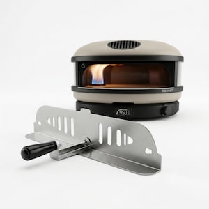 May include: A beige and black outdoor pizza oven with a stainless steel peel. The oven has a digital display showing 450 degrees. A blue flame is visible inside the oven. The oven is labeled "GOZNEY".
