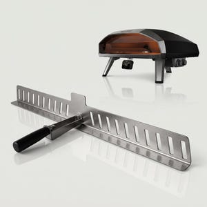 Puede incluir: Una pala para pizza de acero inoxidable con un mango negro y un horno para pizza. La pala tiene una serie de recortes rectangulares a lo largo de su borde. El horno para pizza es negro y plateado con interior marrón.