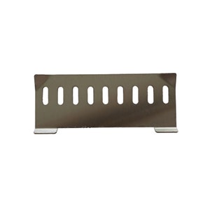 Puede incluir: Una cubierta de ventilaci&oacute;n de metal de acero inoxidable con forma rectangular y una serie de cortes ovales verticales espaciados uniformemente. La cubierta tiene dos peque&ntilde;os pies rectangulares en la parte inferior.