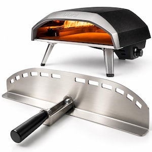 Peut inclure: Un four à pizza Ooni noir et argenté avec une flamme intérieure allumée et une surface de cuisson en pierre, accompagné d'une pelle à pizza en acier inoxydable dotée d'un manche noir et de découpes rectangulaires sur le bord supérieur.