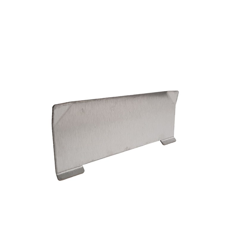 Puede incluir: Un objeto rectangular de metal cepillado, con una superficie plana y dos peque&ntilde;os pies rectangulares. El objeto tiene un borde ligeramente angulado en un lado. El dise&ntilde;o general es simple y moderno.