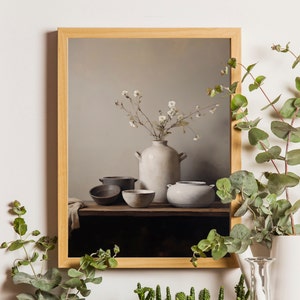 May include: A framed still life painting of a white ceramic vase with a bouquet of white flowers, and four ceramic bowls on a wooden shelf.