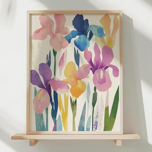 May include: A framed print featuring a colorful abstract floral design with pink, blue, yellow, and purple irises on a white background.