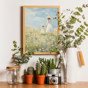 Peut inclure: Une peinture encadr&eacute;e repr&eacute;sentant deux personnes marchant dans un champ de fleurs blanches, un pichet en c&eacute;ramique blanche avec une poign&eacute;e en bois, un bocal en verre, une bouteille en verre transparent et quatre cactus en pot sur une surface en bois.