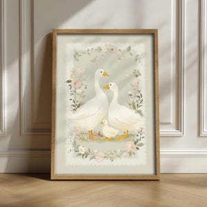 Può includere: Una stampa artistica incorniciata raffigurante una famiglia di oche. Due oche adulte e un'oca piccola sono insieme in un campo di fiori, circondate da una ghirlanda floreale. L'opera d'arte ha una palette di colori pastello e una cornice in legno.
