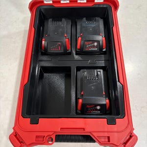 May include: A red and black tool case with a black interior. The case contains three black and red Milwaukee RedLithium batteries. The batteries have a power indicator and are designed for power tools. The case is open and ready for use.