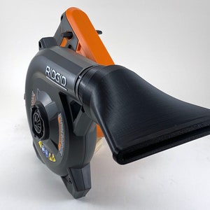 Puede incluir: Un soplador de hojas de mano negro y naranja con una boquilla larga y negra. El soplador tiene la palabra "RIDGID" impresa en el lateral.