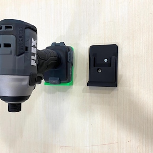May include: A black and silver cordless drill with a green and black charging base and a black wall mount. The drill has the word "FLEX" printed on the side and "BRUSHLESS" printed on the back.