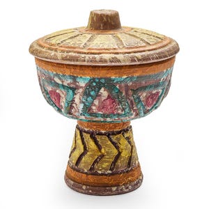May include: A decorative, lidded pedestal bowl with a textured, hand-painted design. The bowl features a brown, orange, yellow, and teal color palette. The base has a chevron pattern, and the bowl's body has a geometric design.