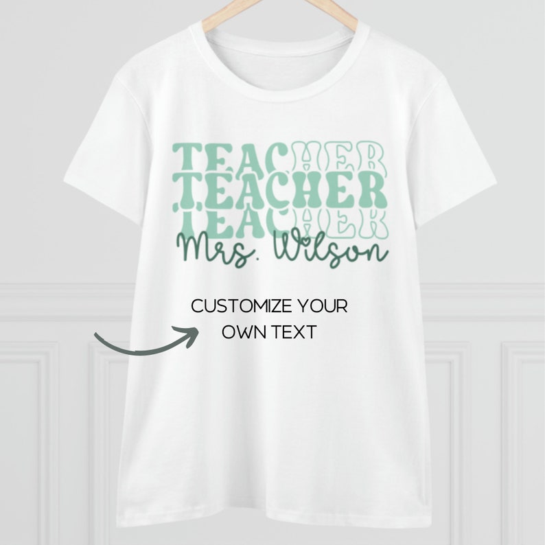 Może przedstawiać: Biała koszulka z zielonym nadrukiem, na kt&oacute;rym wielokrotnie widnieje napis "Teacher" oraz "Mrs. Wilson" na dole. Tekst "Customize your own text" jest r&oacute;wnież umieszczony wraz ze strzałką wskazującą na niego.