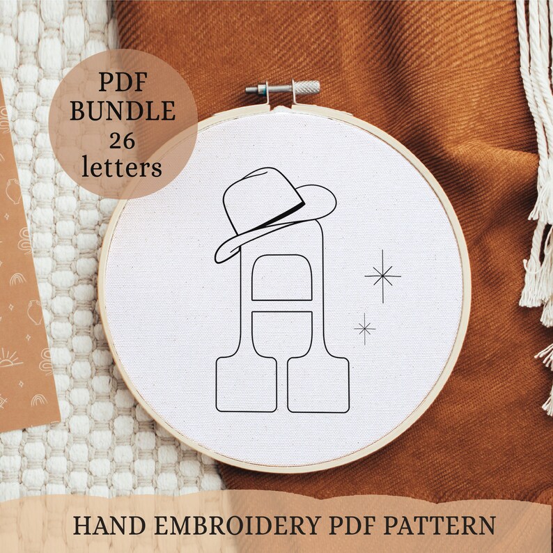 May include: A black and white line drawing of the letter A with a cowboy hat on top. The letter is in a hoop and there are two small stars to the right of the letter. The text "PDF BUNDLE 26 letters" is in the top left corner of the image. The text "HAND EMBROIDERY PDF PATTERN" is at the bottom of the image.
