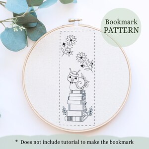 Peut inclure: Motif de marque-page en noir et blanc, avec un escargot portant un chapeau et un nœud papillon assis sur une pile de livres avec des fleurs. Le motif est sur fond blanc.