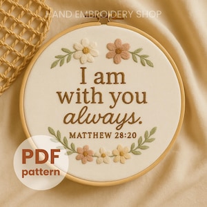 Könnte beinhalten: Ein runder Stickrahmen mit dem Text "I am with you always" und "Matthew 28:20", gestickt mit braunem Faden. Das Design umfasst gestickte Blumen und Blätter in Creme, Pfirsich und Grün. Ein "PDF pattern"-Aufkleber befindet sich unten links.