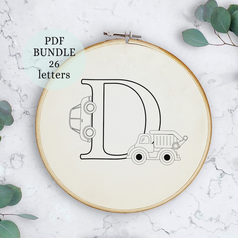 May include: A black and white embroidery hoop with the letter D in the centre. A car and a dump truck are partially hidden behind the letter. The text "PDF BUNDLE 26 letters" is in the top left corner of the image.