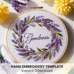 May include: A hand embroidery template featuring a wreath of lavender flowers with the word "Goodness" in the centre. The template is in a wooden embroidery hoop.