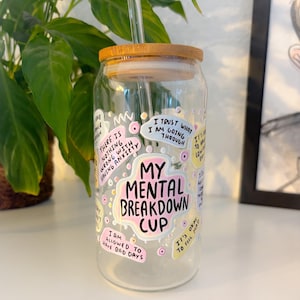 Könnte beinhalten: Ein klares Glas mit einem Bambusdeckel und einem Strohhalm. Der Becher ist mit den Worten "My Mental Breakdown Cup" und anderen Sätzen wie "I am allowed to have bad days" verziert. Der Becher ist von rosa und gelben Akzenten umgeben.