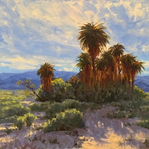 May include: An oil painting depicts a desert landscape with palm trees. The artwork features a cluster of tall palm trees with brown trunks and green fronds, set against a backdrop of blue mountains and a cloudy sky. The foreground shows desert vegetation.
