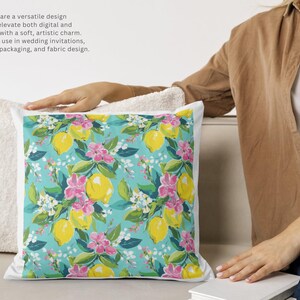 May include: A square decorative pillow with a vibrant floral pattern featuring yellow lemons, pink flowers, and green leaves on a turquoise background. The pillow is placed next to a white, textured pillow.