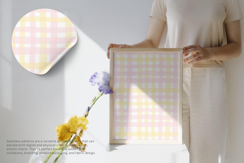 May include: A framed print and a sticker featuring a pastel pink, yellow, and white gingham pattern. The print is held by a person. The image also includes yellow and purple flowers.