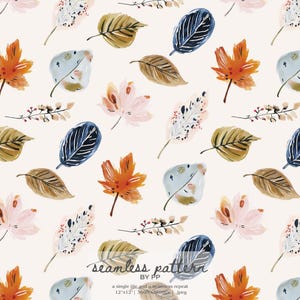 May include: A seamless pattern featuring watercolor illustrations of autumn leaves in shades of orange, brown, blue, and pink on a cream background. The design includes maple leaves, stylized leaves, and sprigs. The text "seamless pattern" is visible.