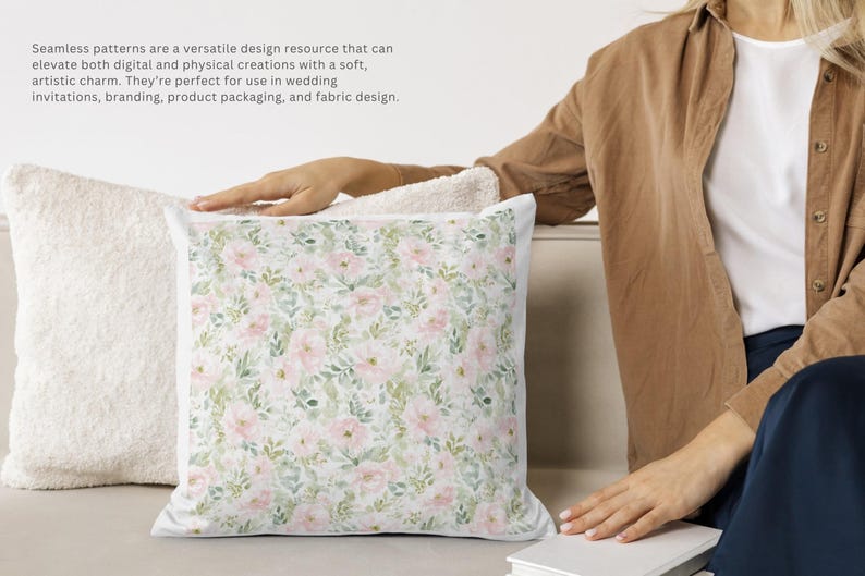 Pode incluir: Uma almofada decorativa com um padr&atilde;o floral de rosas cor-de-rosa e folhas verdes sobre um fundo branco. A almofada est&aacute; ao lado de uma almofada branca e fofa. A imagem inclui texto sobre padr&otilde;es sem costura para design.