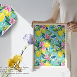 May include: A framed print and a sticker featuring a seamless pattern of yellow lemons, pink flowers, and green leaves on a turquoise background. The print is held by a person. The text reads: Seamless patterns are a versatile design resource.