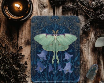 May include: A rectangular, dark blue decorative item featuring a large, light green Luna moth with purple accents, set against a backdrop of bluebell flowers. The design has a vintage, botanical aesthetic. The item is placed on a wooden surface.