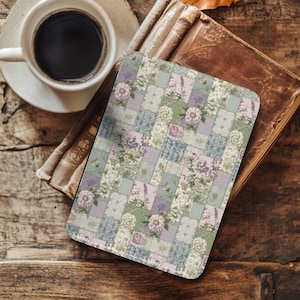 May include: A floral patterned coaster with a patchwork design featuring pastel colors of lavender, green, and blue. The coaster is placed on a vintage book next to a cup of coffee, creating a cozy, rustic aesthetic.