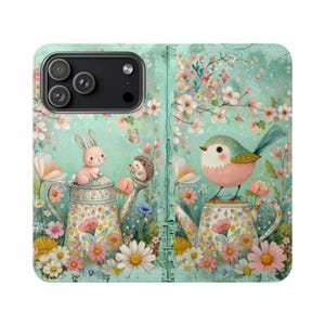 May include: A mint green phone case featuring a whimsical garden scene. A pink bunny and hedgehog sit atop floral teapots, with a bird perched on another. The design includes flowers, butterflies, and cherry blossoms.