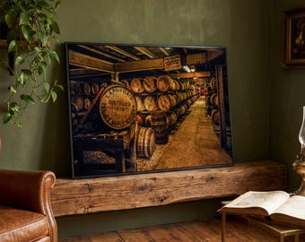 May include: A framed print of a whiskey distillery interior. The image shows rows of wooden barrels in a dimly lit room. A large barrel with the text "Laphroaig Distilled 1815" is in the foreground. The print is displayed on a wooden beam.