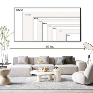Op de afbeelding: Een witte canvasprint met een zwarte lijst, die verschillende formaten van de print laat zien. De print is 115 inch breed. De print wordt weergegeven op een witte muur boven een grijze hoekbank met een witte salontafel en een witte accentstoel.