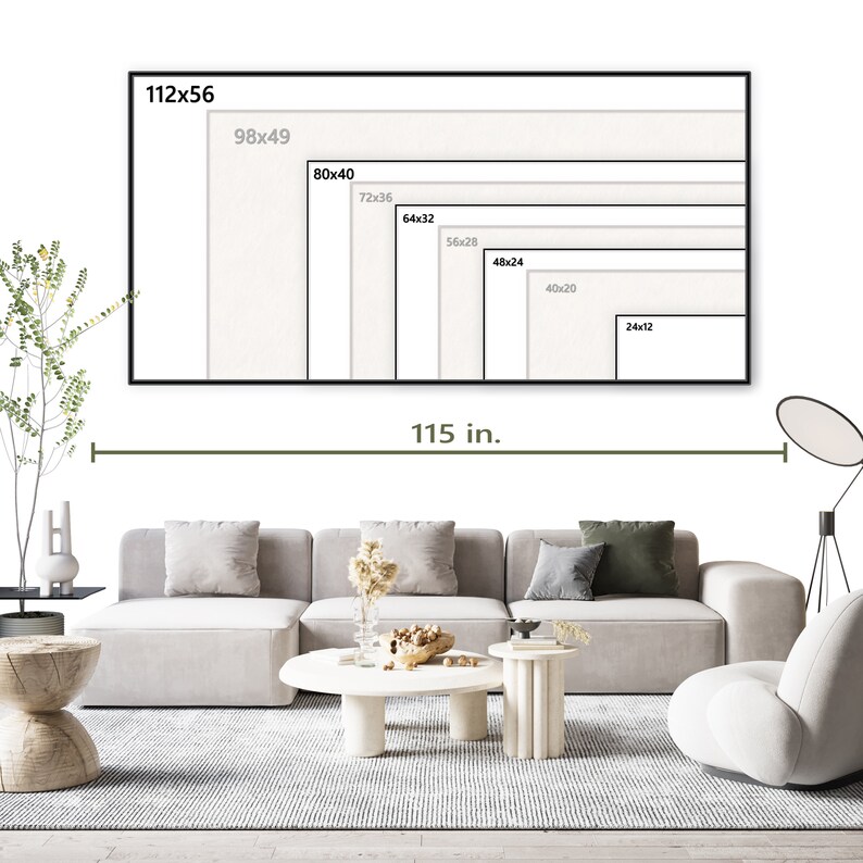 Op de afbeelding: Een witte canvasprint met een zwarte lijst, die verschillende formaten van de print laat zien. De print is 115 inch breed. De print wordt weergegeven op een witte muur boven een grijze hoekbank met een witte salontafel en een witte accentstoel.