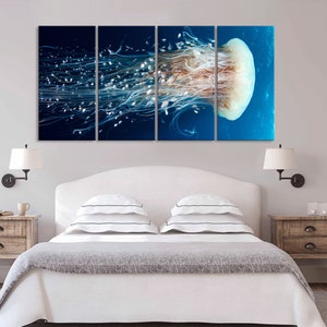 Op de afbeelding: Een meerdelige wandkunstprint met een close-up van een kwal met lange, stromende tentakels tegen een blauwe achtergrond.