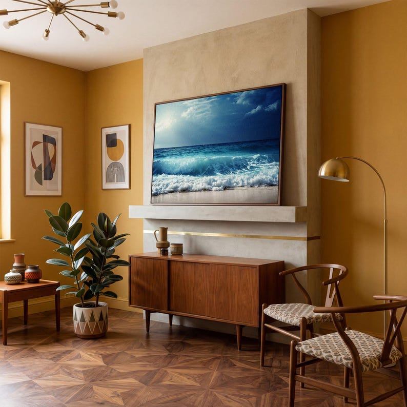 May include: A living room with a large framed picture of ocean waves above a wooden cabinet. Two chairs with patterned seats and a floor lamp are in front of a mustard-colored wall. A potted plant and artwork complete the room's decor.