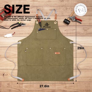 Peut inclure: Un tablier vert olive avec des sangles grises et des d&eacute;tails en cuir. Le tablier comporte plusieurs poches et le nom "Hudson" brod&eacute; sur le devant. Il mesure 73,7 cm de hauteur et 70,1 cm de largeur.