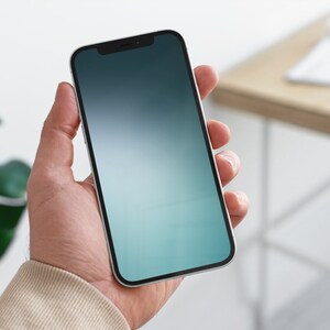 May include: A person holding a white smartphone with a black bezel and a gradient blue and green screen.